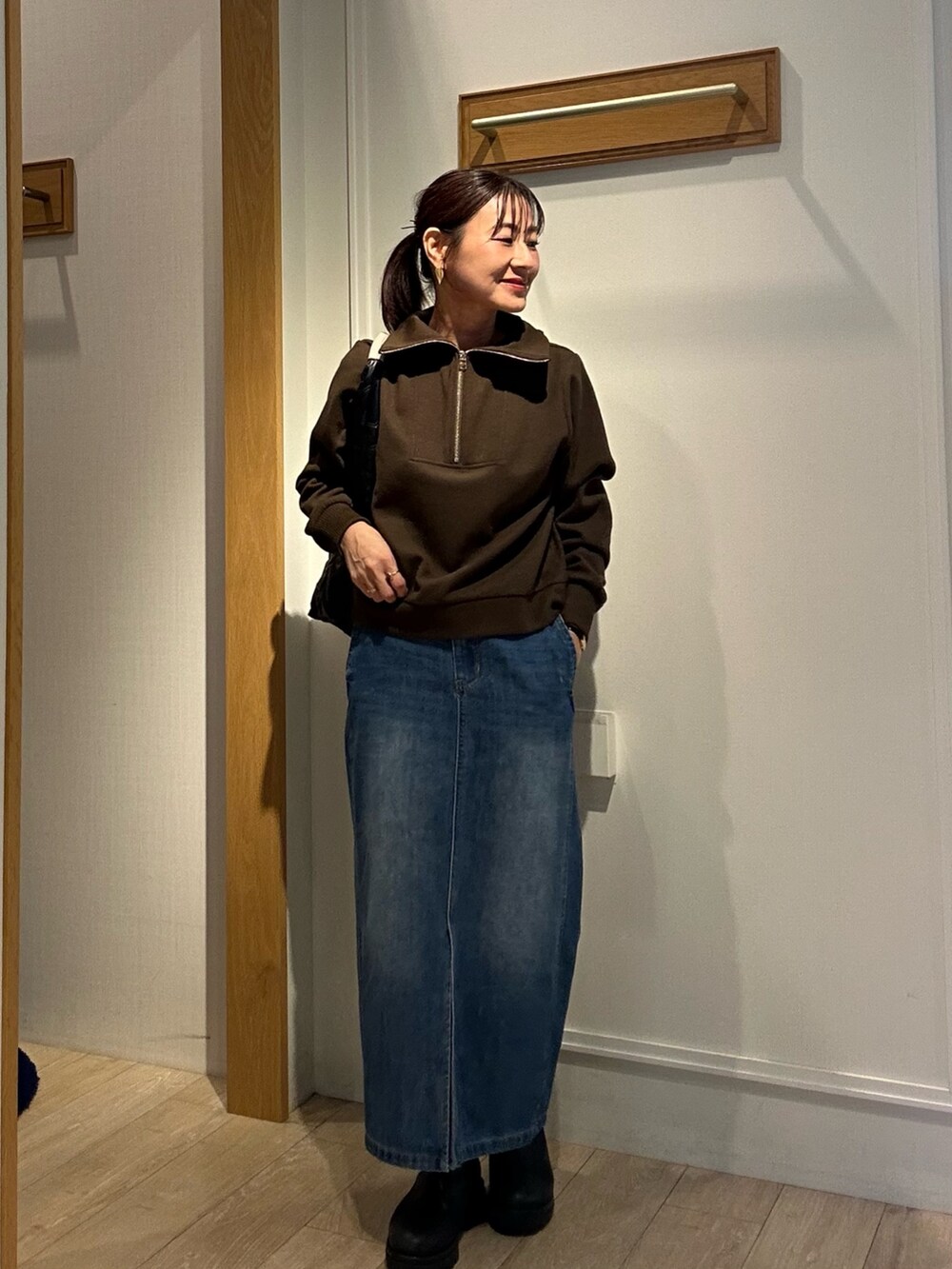 ブラック系のトートバッグ、ホワイト系のブルゾン、ブラウン系のTシャツ/カットソーを着用したレディースの秋コーディネートの2枚目の写真