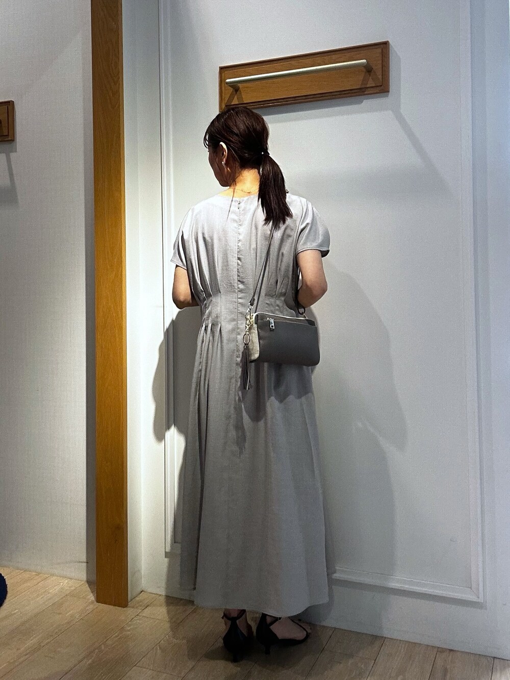 ベージュ系のワンピース、ブルー系のカーディガン/ボレロ、グレー系のショルダーバッグを着用したレディースの春コーディネートの3枚目の写真
