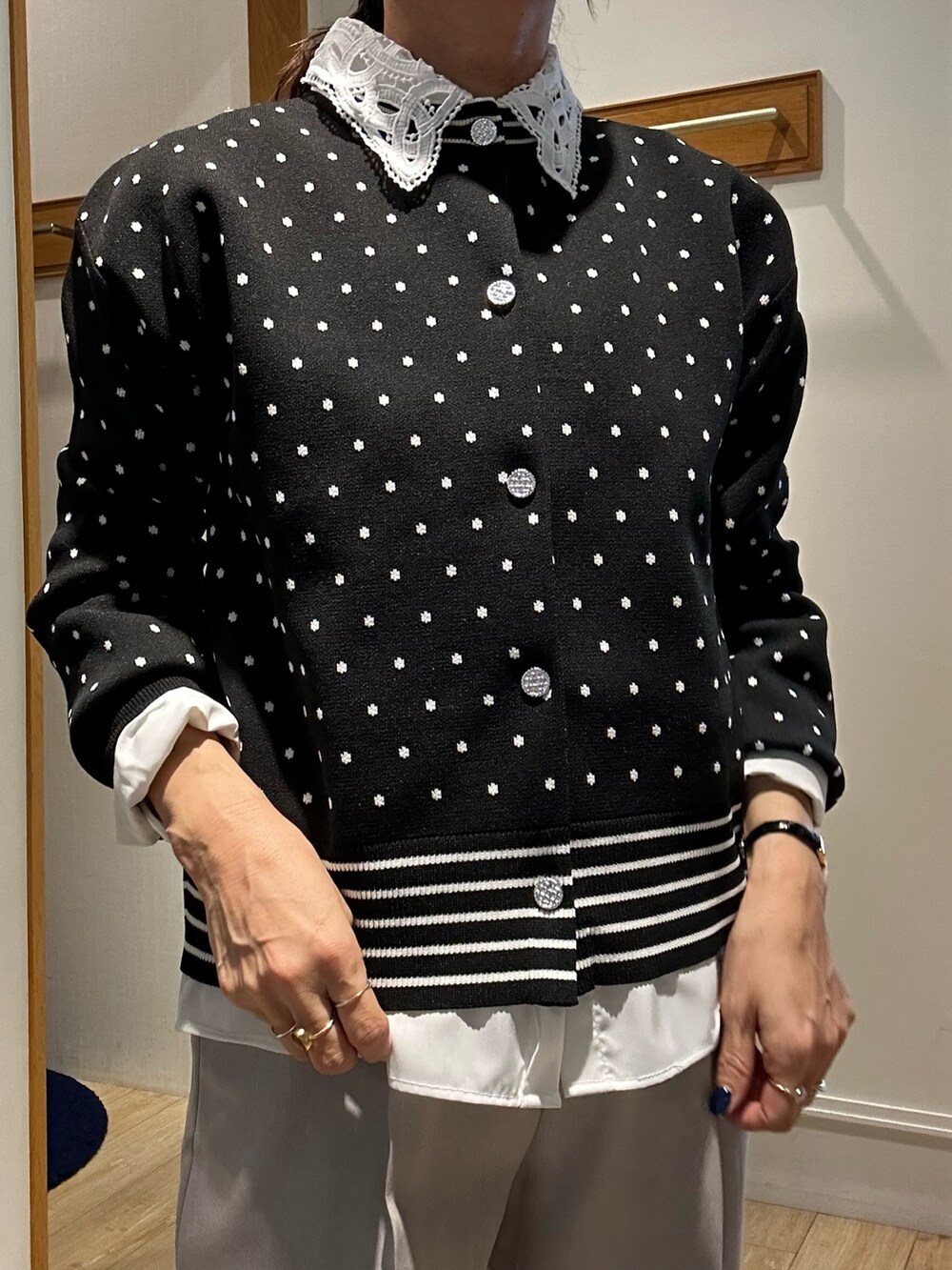 ブラック系のニット/セーター、ブラック系のショルダーバッグ、ホワイト系のシャツ/ブラウスを着用したレディースの冬コーディネートの7枚目の写真