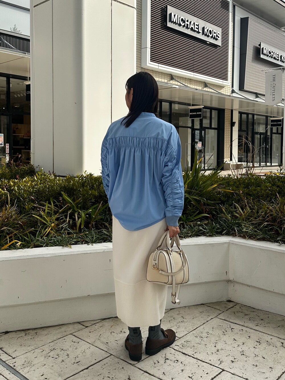 ホワイト系のパーカー、ブルー系のシャツ/ブラウス、ホワイト系のスカートを着用したレディースの冬コーディネートの4枚目の写真