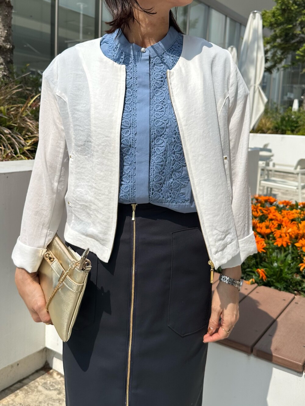 ホワイト系のブルゾン、グレー系のTシャツ/カットソー、グリーン系のスカートを着用したレディースの春コーディネートの5枚目の写真