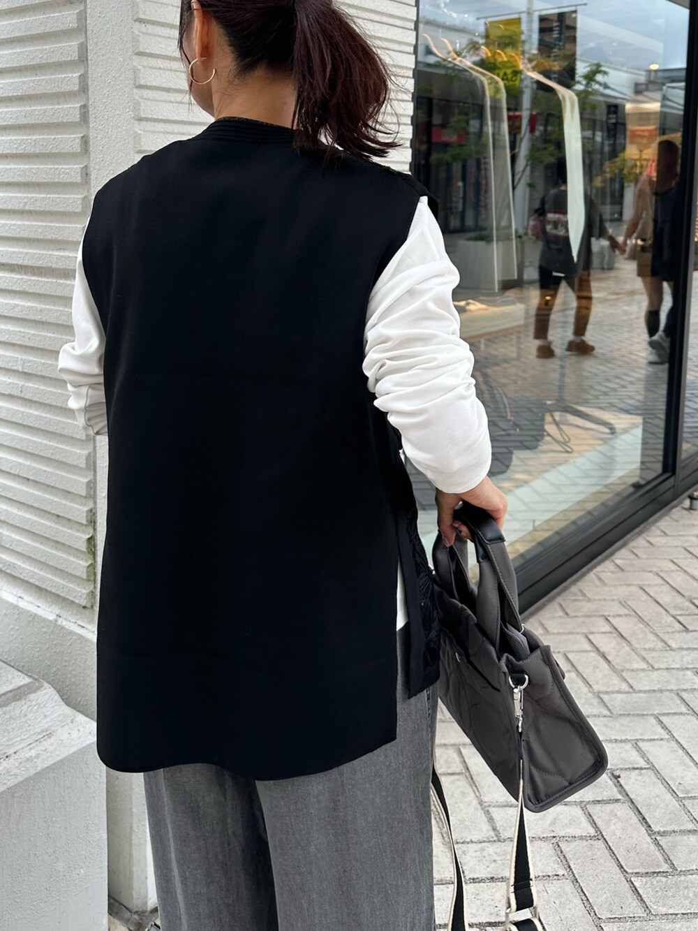 グレー系のデニムパンツ、ブラック系のニット/セーター、グレー系のトートバッグを着用したレディースの秋コーディネートの5枚目の写真
