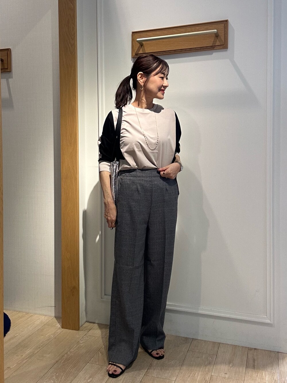 ベージュ系のTシャツ/カットソー、グレー系のその他パンツ、ブラック系のサンダルを着用したレディースの秋コーディネートの5枚目の写真