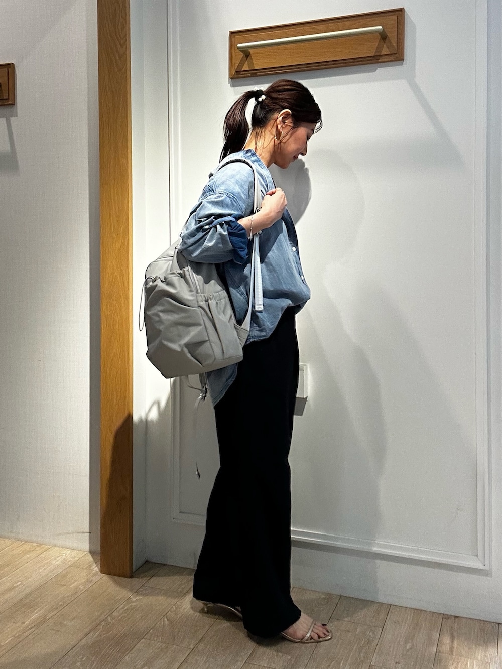 グレー系のバックパック/リュック、ホワイト系のTシャツ/カットソー、ブルー系のシャツ/ブラウスを着用したレディースの春コーディネートの5枚目の写真