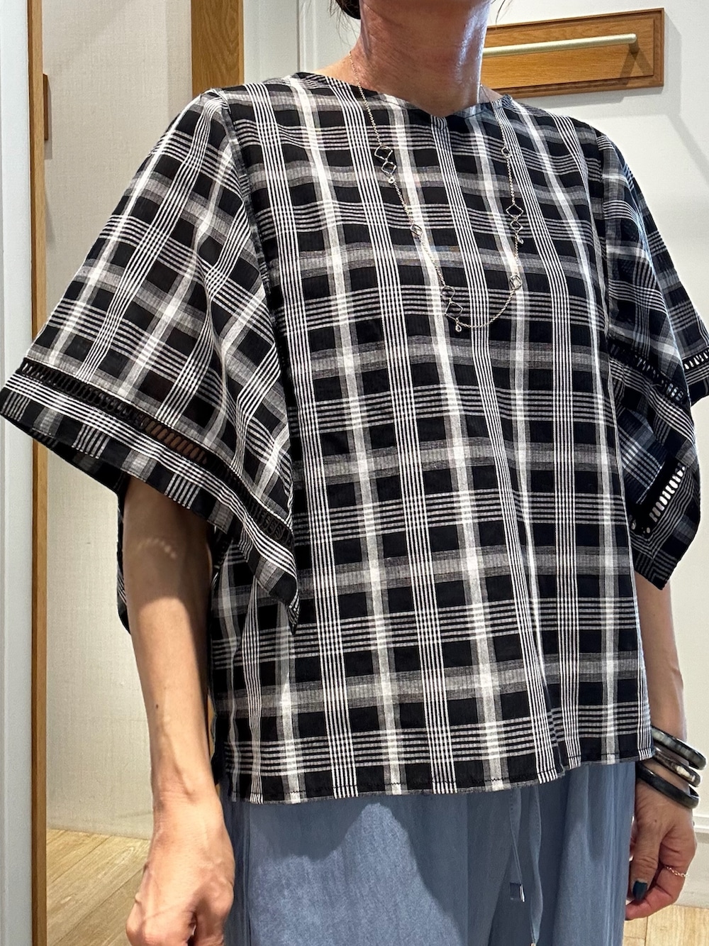 ブラック系のシャツ/ブラウス、ブルー系のデニムパンツを着用したレディースの夏コーディネートの5枚目の写真