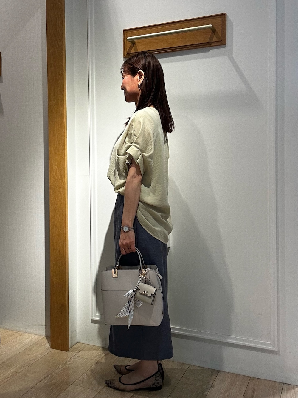 イエロー系のシャツ/ブラウス、ブルー系のスカート、グレー系のTシャツ/カットソーを着用したレディースの春コーディネートの4枚目の写真