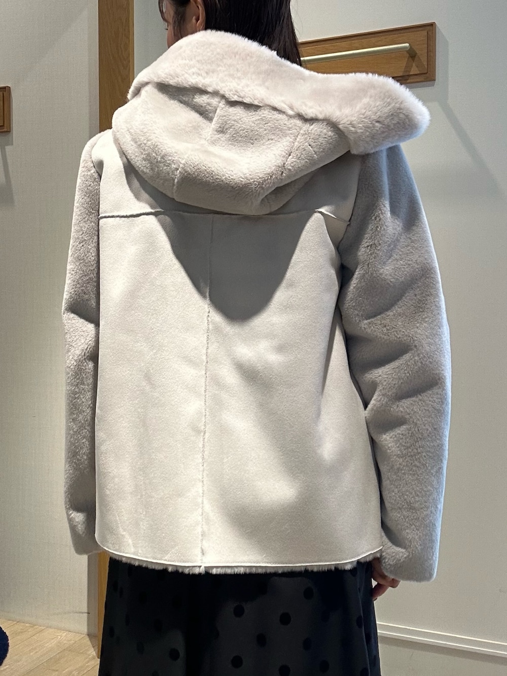 ベージュ系のムートンコート、ブルー系のニット/セーター、ホワイト系のニット/セーターを着用したレディースの冬コーディネートの7枚目の写真