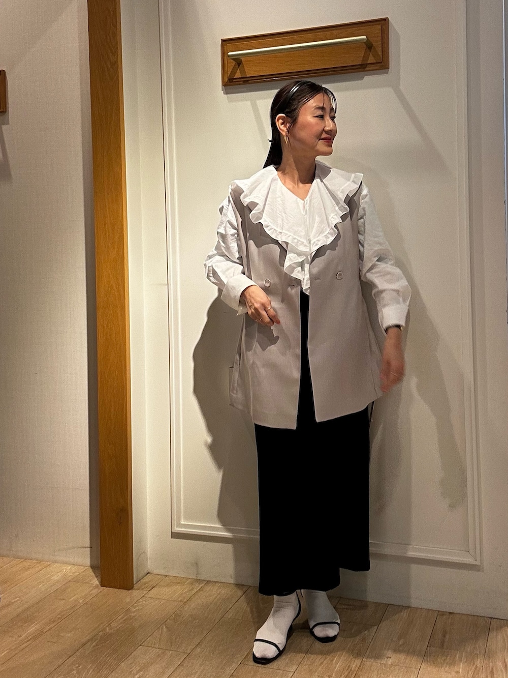 ベージュ系のダウンジャケット/コート、ホワイト系のシャツ/ブラウス、ブラック系のスカートを着用したレディースの春コーディネートの4枚目の写真