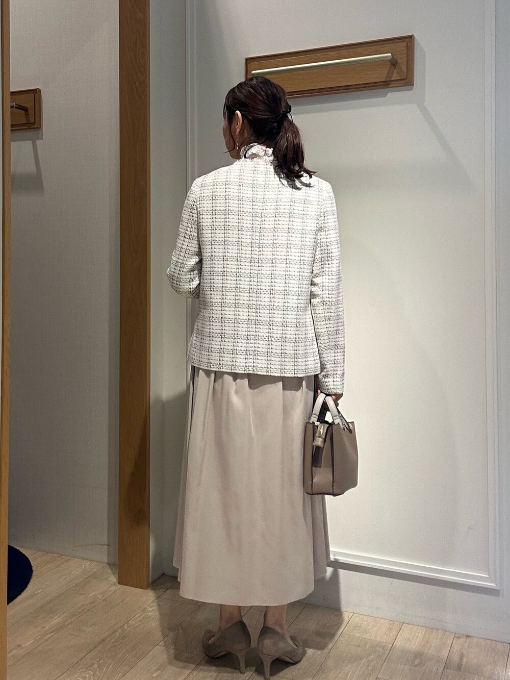 ホワイト系のノーカラージャケット、ベージュ系のスカート、ホワイト系のTシャツ/カットソーを着用したレディースの冬コーディネートの2枚目の写真