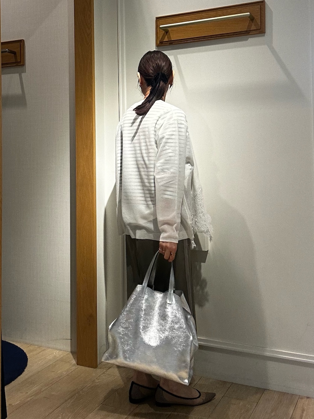 ホワイト系のTシャツ/カットソー、ホワイト系のカーディガン/ボレロ、グリーン系のスカートを着用したレディースの冬コーディネートの10枚目の写真