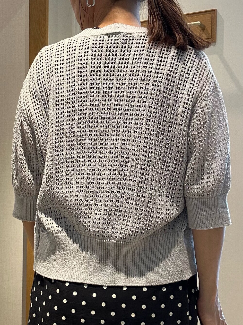 グレー系のニット/セーター、ブラック系のワンピース、ブラック系のサンダルを着用したレディースの春コーディネートの7枚目の写真