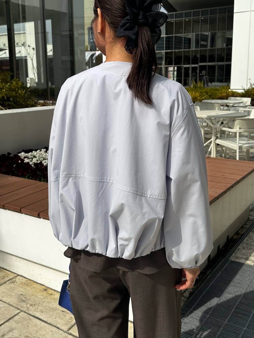 ブルー系のブルゾン、グリーン系のシャツ/ブラウス、ブルー系のショルダーバッグを着用したレディースの春コーディネートの6枚目の写真