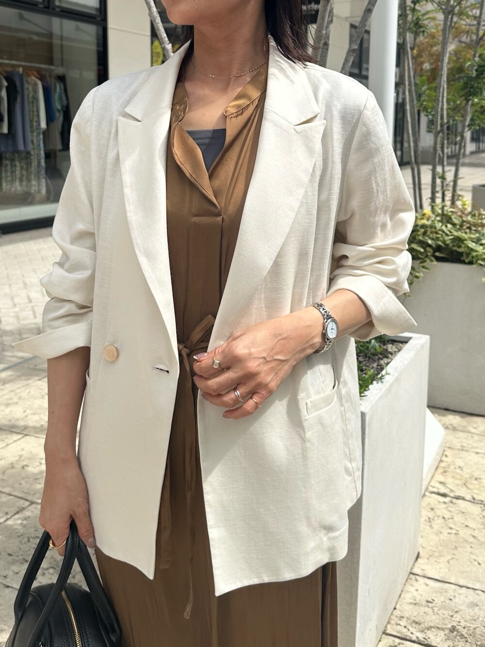 ブラウン系のワンピース、グレー系のTシャツ/カットソー、ホワイト系のテーラードジャケットを着用したレディースの夏コーディネートの7枚目の写真