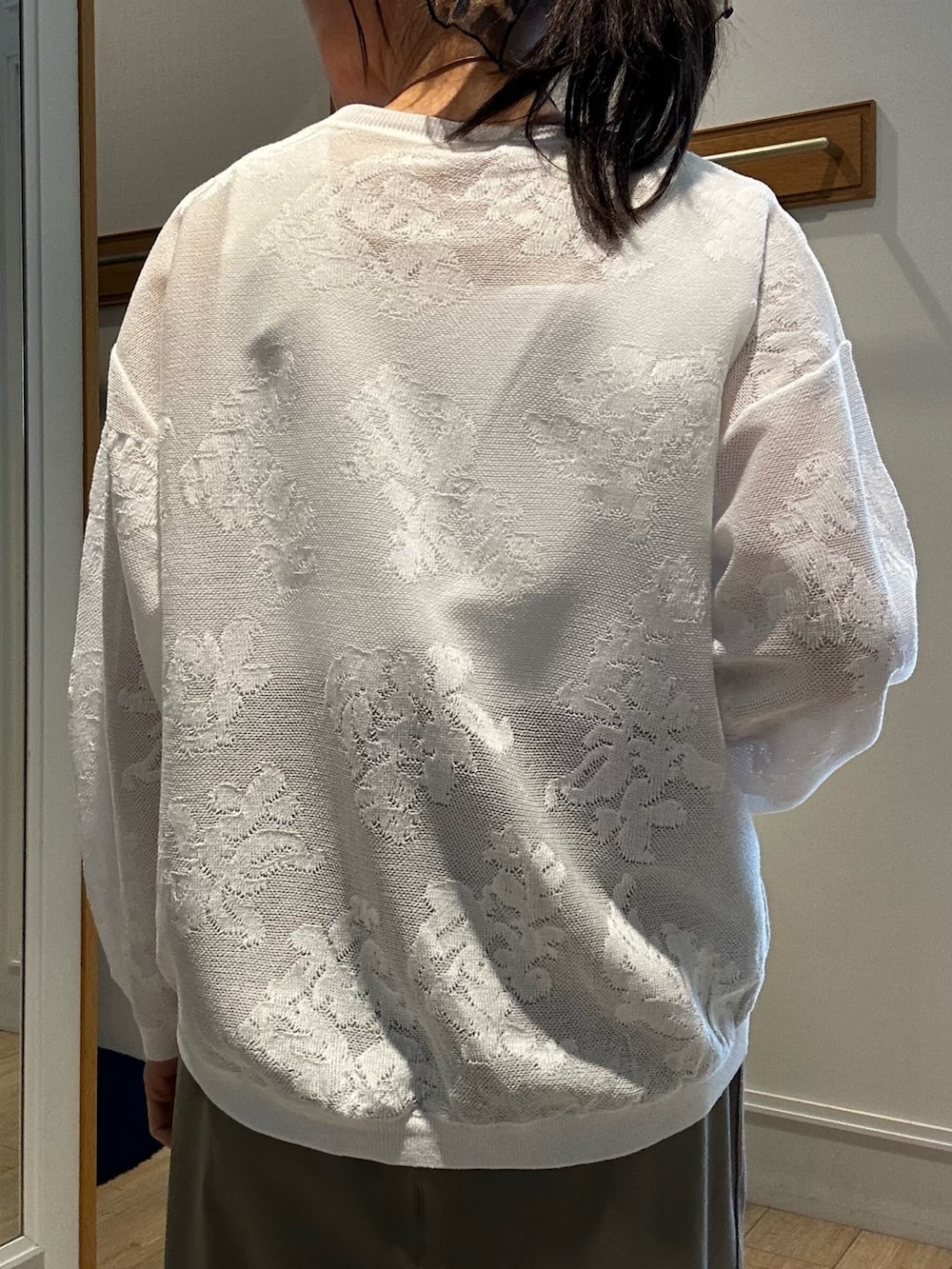 ホワイト系のニット/セーター、ホワイト系のTシャツ/カットソー、グリーン系のスカートを着用したレディースの春コーディネートの7枚目の写真