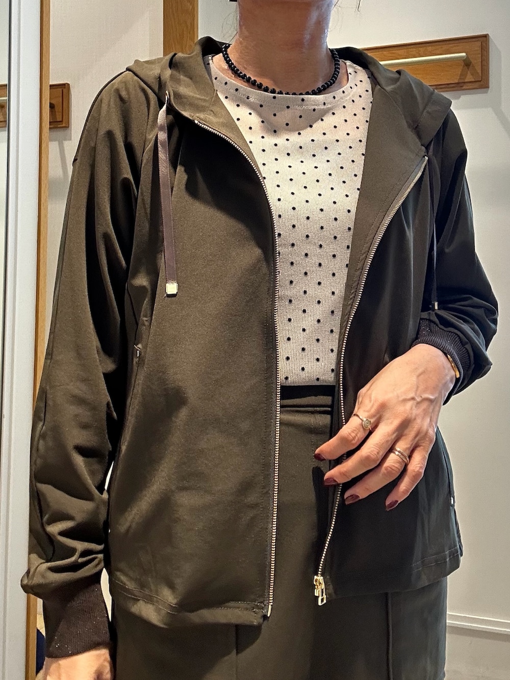 グリーン系のブルゾン、ベージュ系のTシャツ/カットソー、ブラック系のトートバッグを着用したレディースの秋コーディネートの5枚目の写真