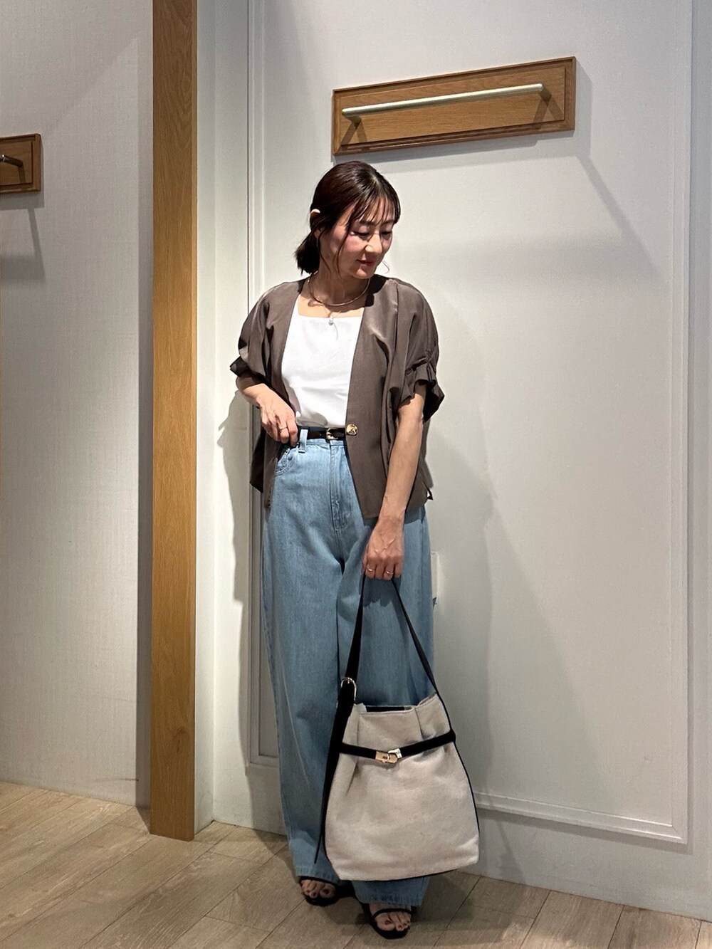 グリーン系のノーカラージャケット、ブルー系のデニムパンツ、ブラック系のサンダルを着用したレディースの夏コーディネートの4枚目の写真