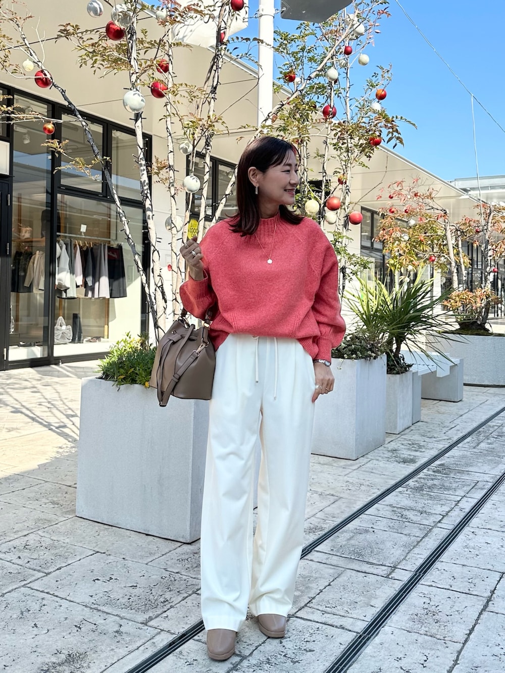 ブラウン系のブルゾン、オレンジ系のニット/セーターを着用したレディースの冬コーディネートの8枚目の写真