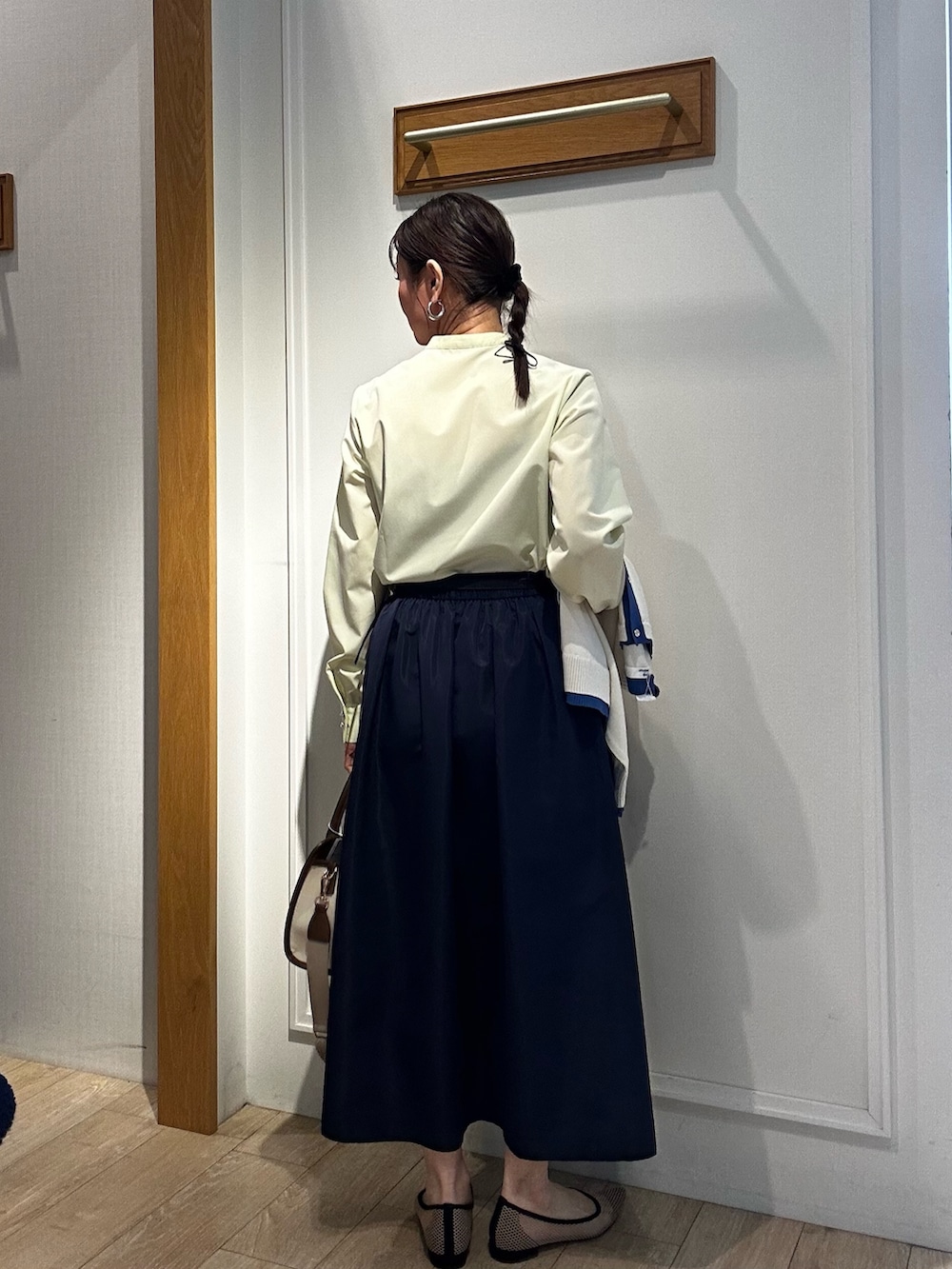 イエロー系のシャツ/ブラウス、ホワイト系のブルゾン、ブルー系のスカートを着用したレディースの冬コーディネートの10枚目の写真