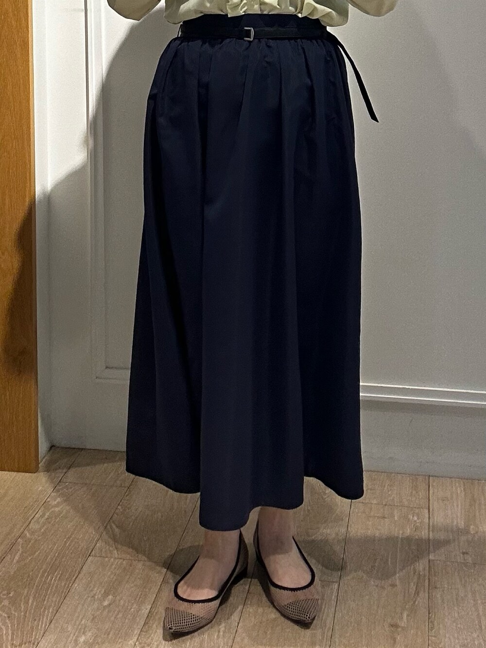 イエロー系のシャツ/ブラウス、ブルー系のスカート、ホワイト系のニット/セーターを着用したレディースの冬コーディネートの6枚目の写真