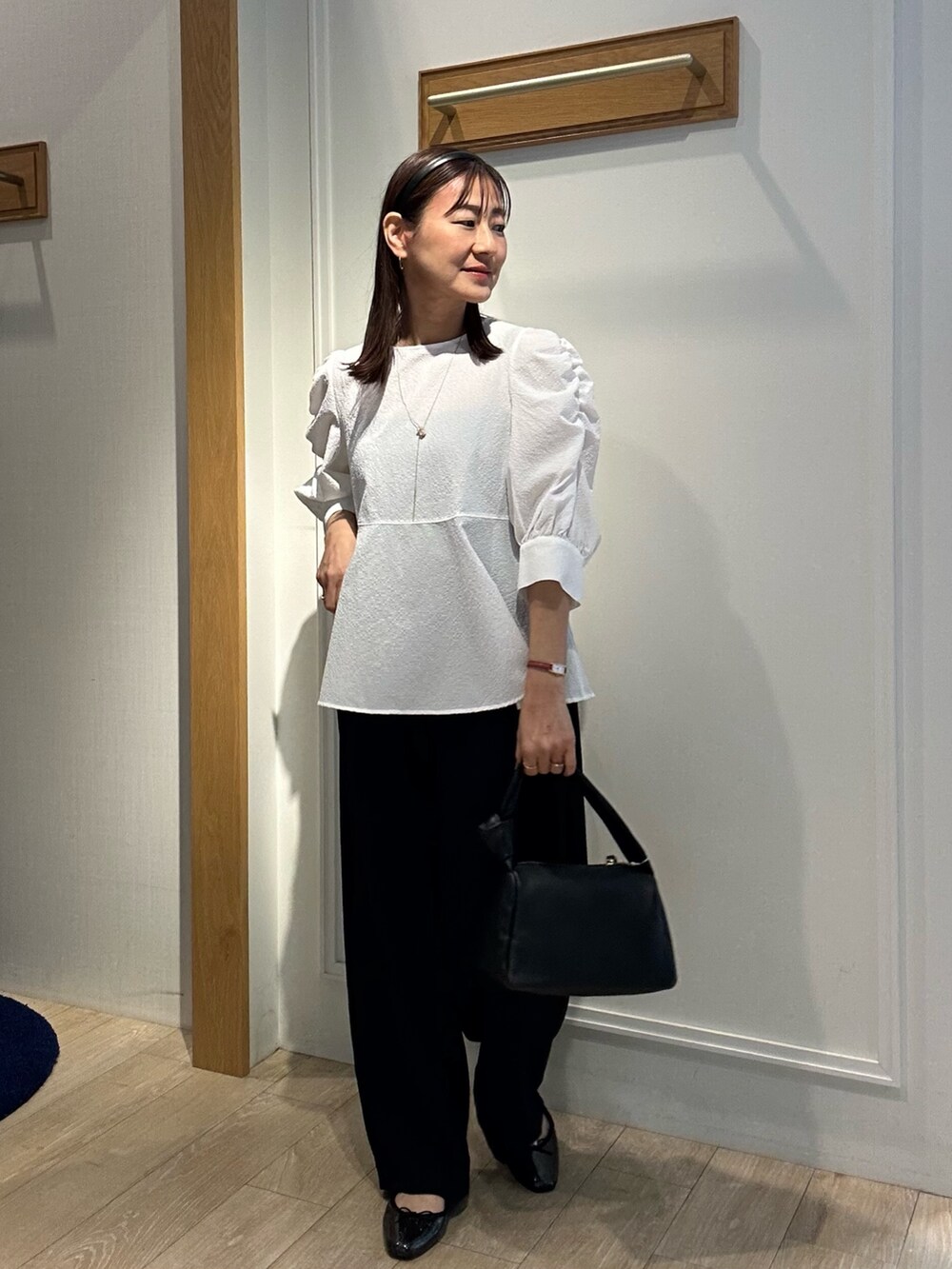 ホワイト系のシャツ/ブラウス、ブルー系のその他パンツ、ブラック系のショルダーバッグを着用したレディースの春コーディネートの2枚目の写真