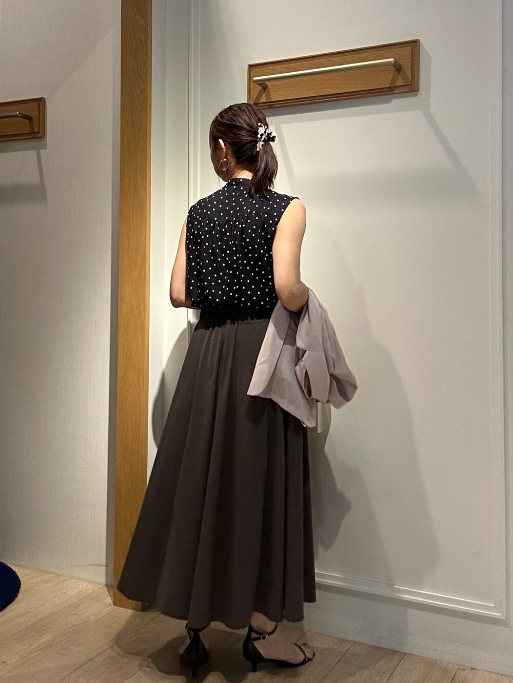 ブラック系のシャツ/ブラウス、グレー系のスカート、ベージュ系のボストンバッグを着用したレディースの夏コーディネートの3枚目の写真