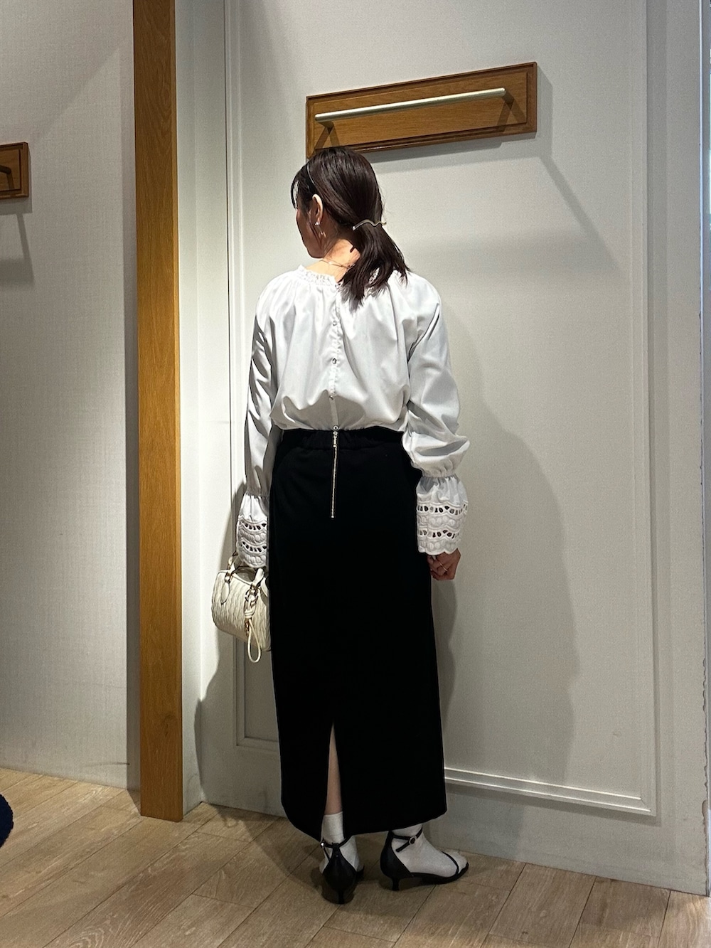 ホワイト系のショルダーバッグ、ホワイト系のシャツ/ブラウス、ベージュ系のブルゾンを着用したレディースの冬コーディネートの8枚目の写真