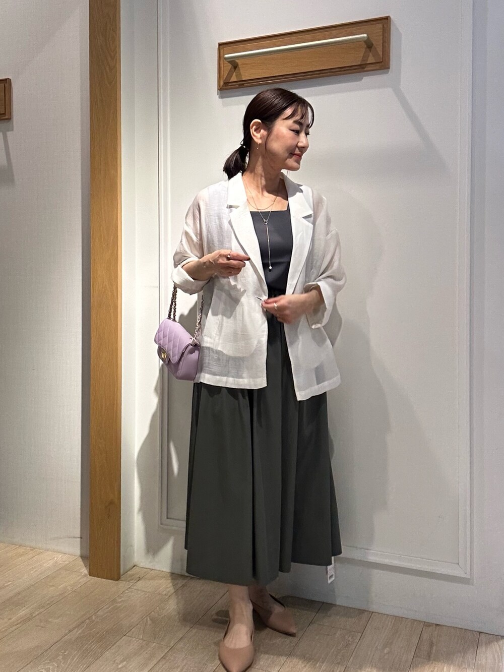 ホワイト系のテーラードジャケット、グレー系のTシャツ/カットソー、ブラック系のスカートを着用したレディースの春コーディネートの10枚目の写真