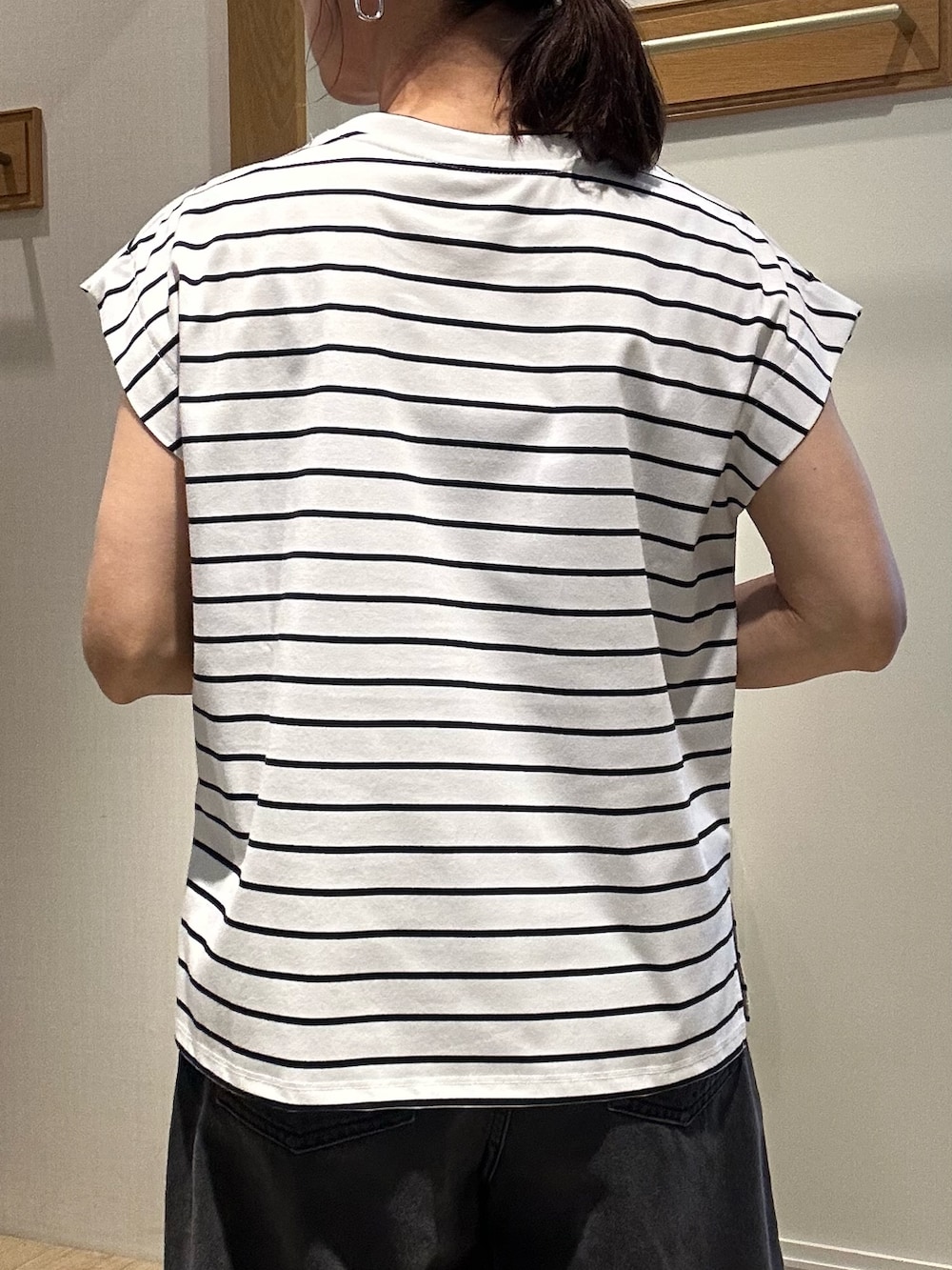 ホワイト系のTシャツ/カットソー、ブラック系のサンダル、ホワイト系のボストンバッグを着用したレディースの夏コーディネートの9枚目の写真
