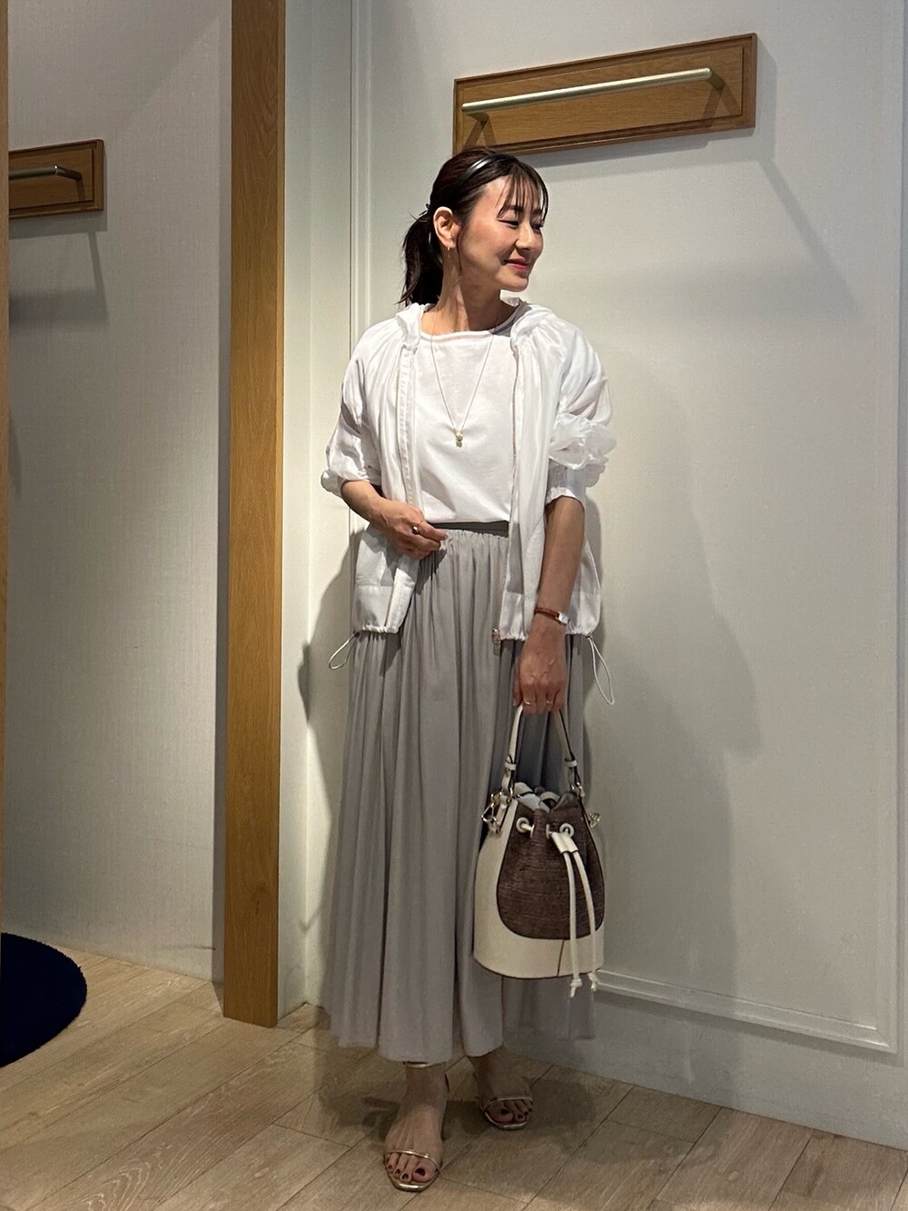 ホワイト系のTシャツ/カットソー、ベージュ系のスカート、ホワイト系のブルゾンを着用したレディースの春コーディネートの10枚目の写真