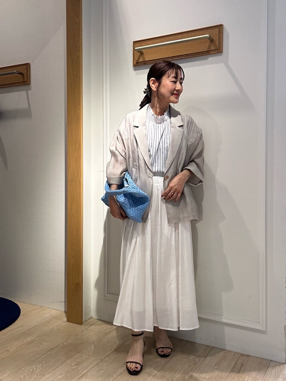 ホワイト系のシャツ/ブラウス、ホワイト系のスカート、ブルー系のショルダーバッグを着用したレディースの春コーディネートの10枚目の写真