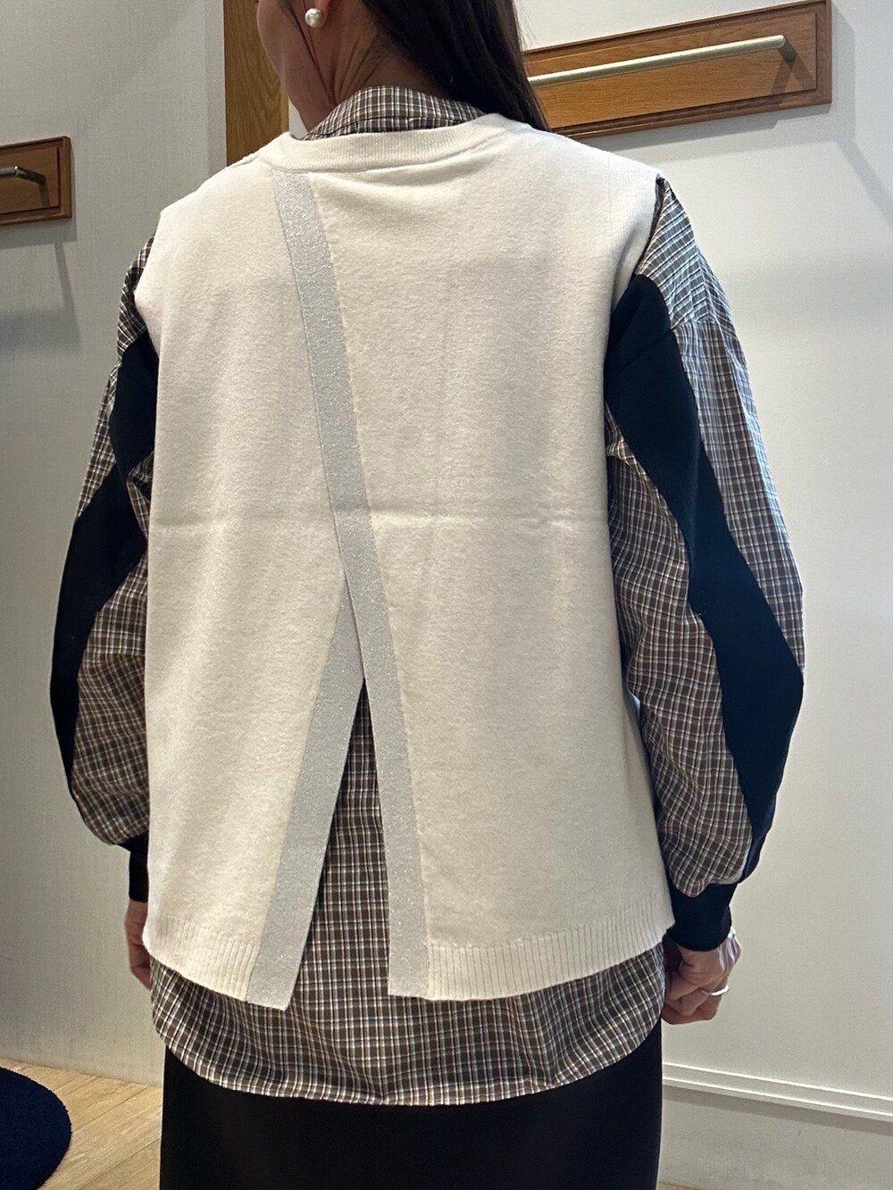 ホワイト系のニット/セーター、ブラック系のスカート、ブラウン系のシャツ/ブラウスを着用したレディースの秋コーディネートの6枚目の写真