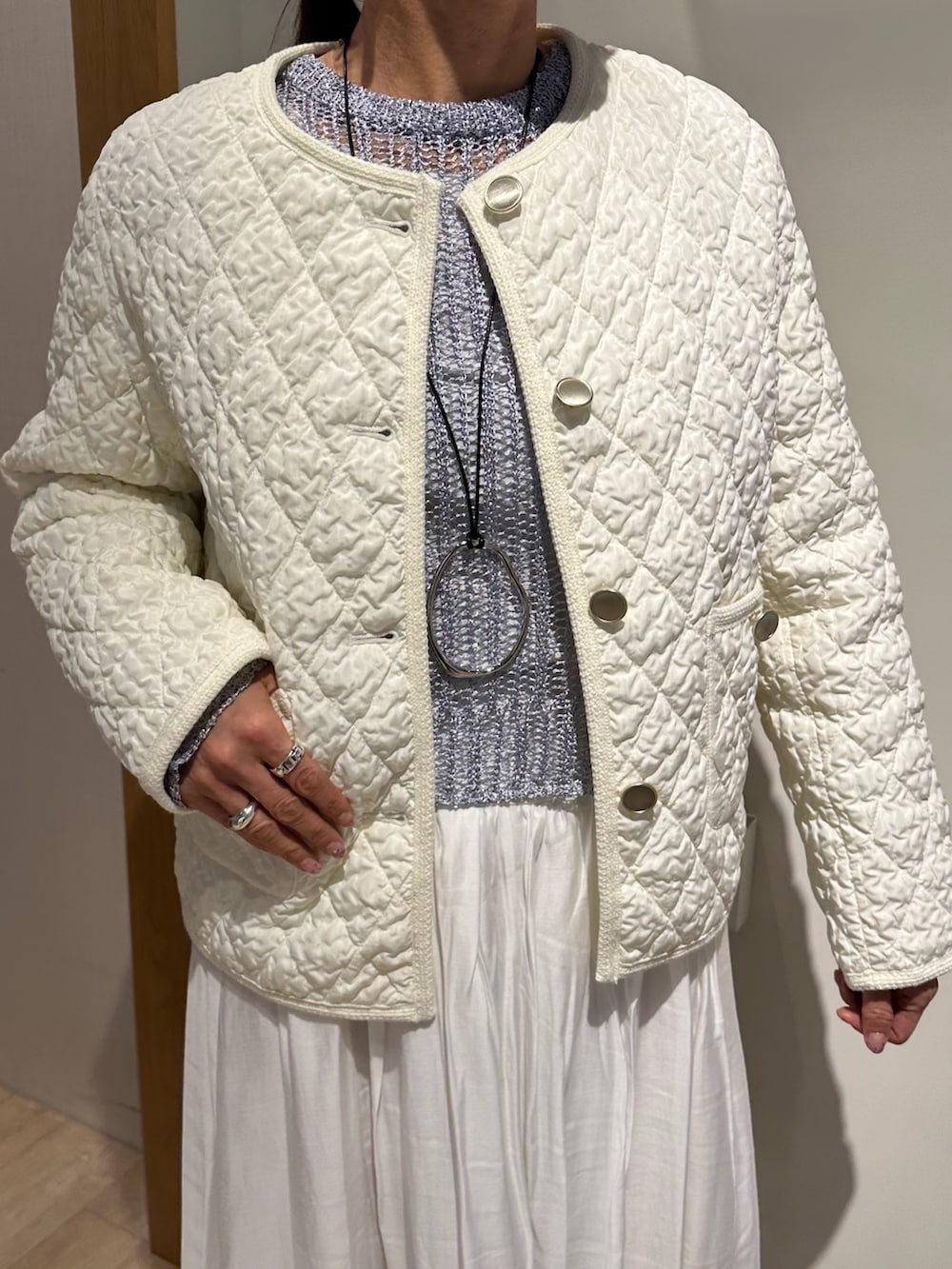 ホワイト系のブルゾン、ブルー系のニット/セーター、ホワイト系のスカートを着用したレディースの冬コーディネートの5枚目の写真