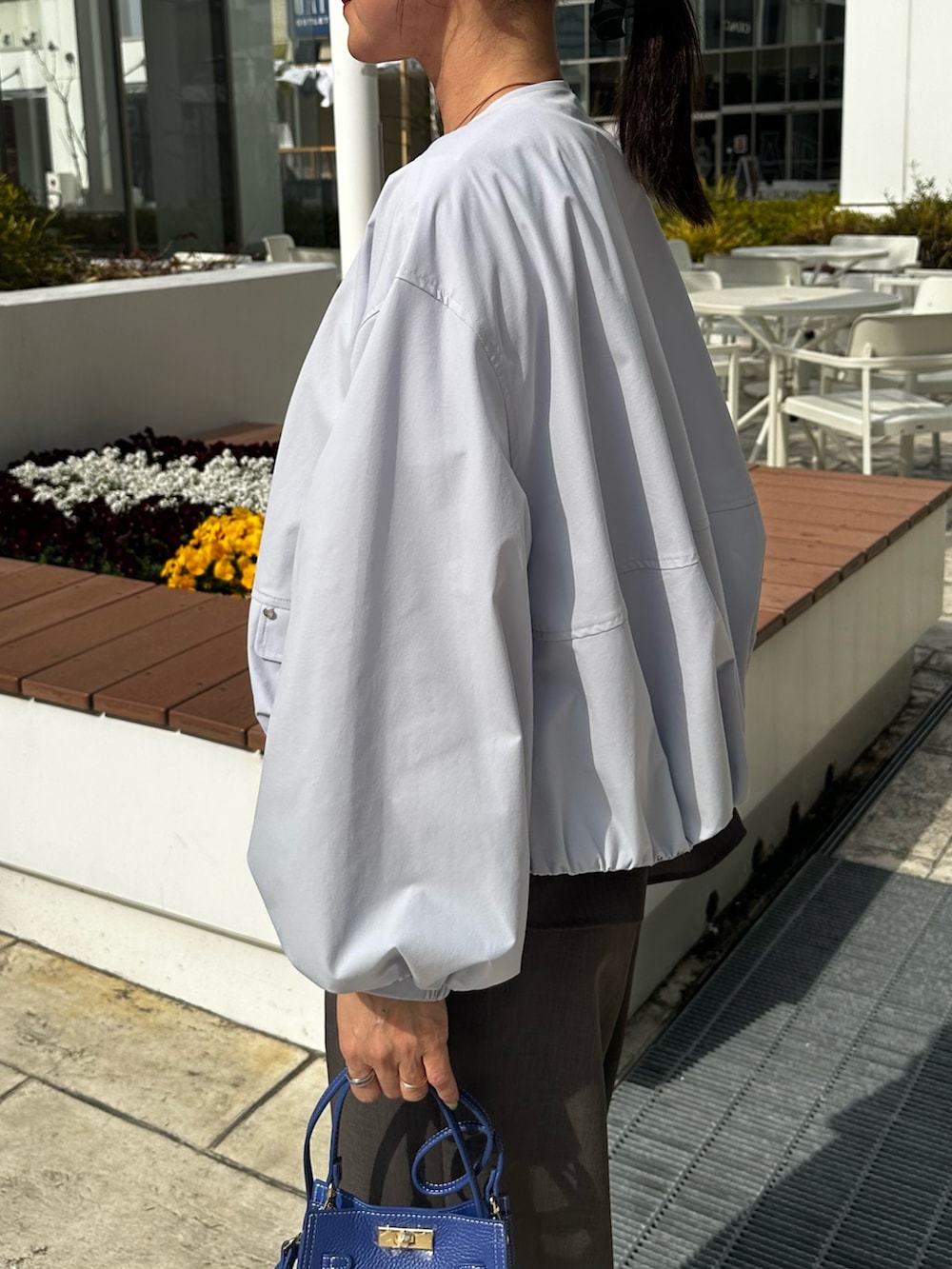 ブルー系のブルゾン、グリーン系のシャツ/ブラウス、ブルー系のショルダーバッグを着用したレディースの春コーディネートの5枚目の写真