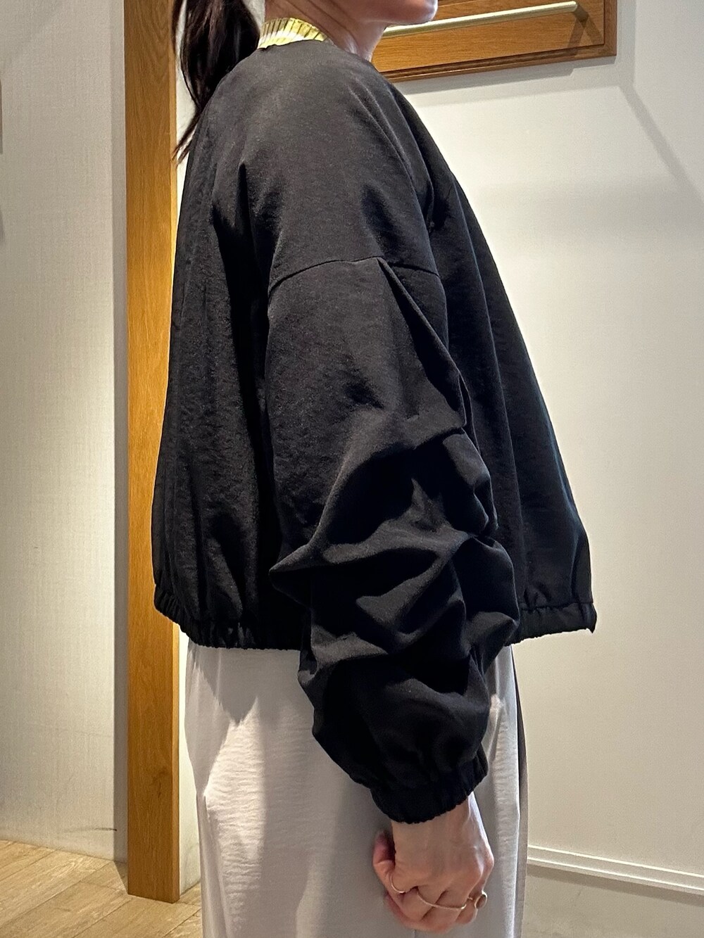 ベージュ系のその他パンツ、イエロー系のカーディガン/ボレロ、ブラック系のブルゾンを着用したレディースの春コーディネートの6枚目の写真