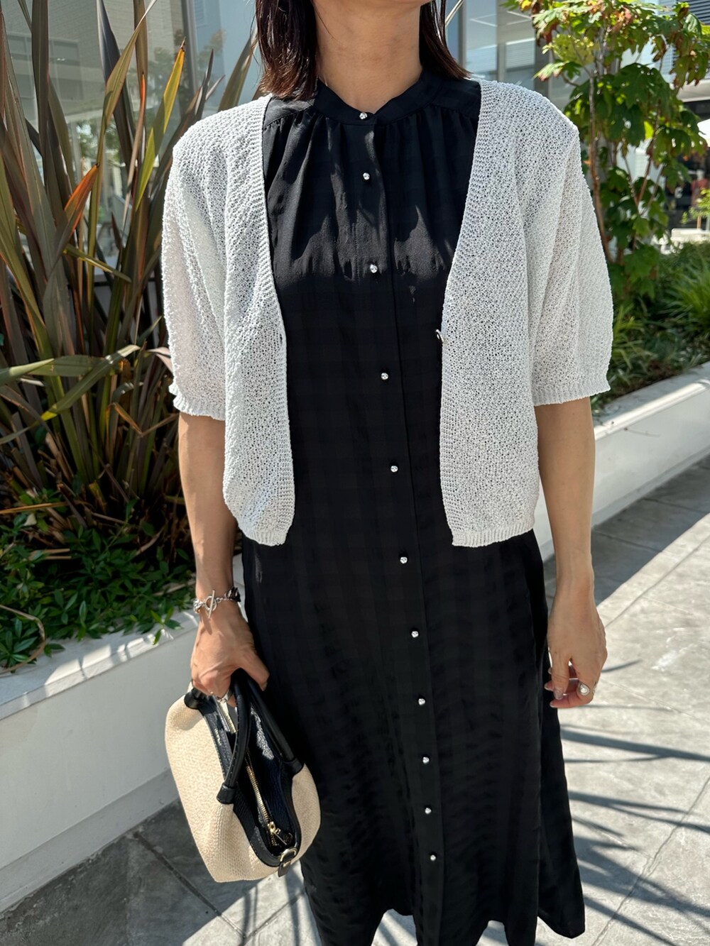 ブラック系のワンピース、ホワイト系のカーディガン/ボレロ、ブラック系のバックパック/リュックを着用したレディースの夏コーディネートの4枚目の写真