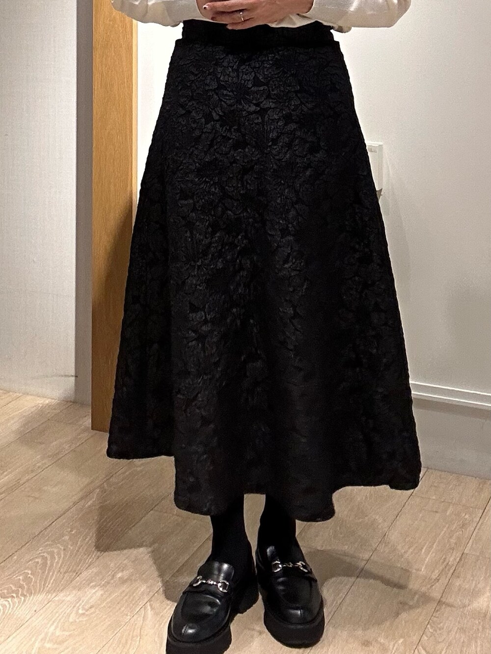 グリーン系のニット/セーター、グレー系のスカート、イエロー系のブルゾンを着用したレディースの秋コーディネートの8枚目の写真