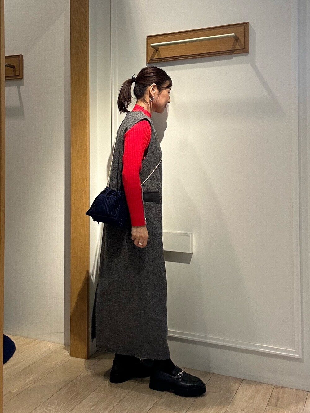グレー系のワンピース、レッド系のニット/セーターを着用したレディースの秋コーディネートの4枚目の写真