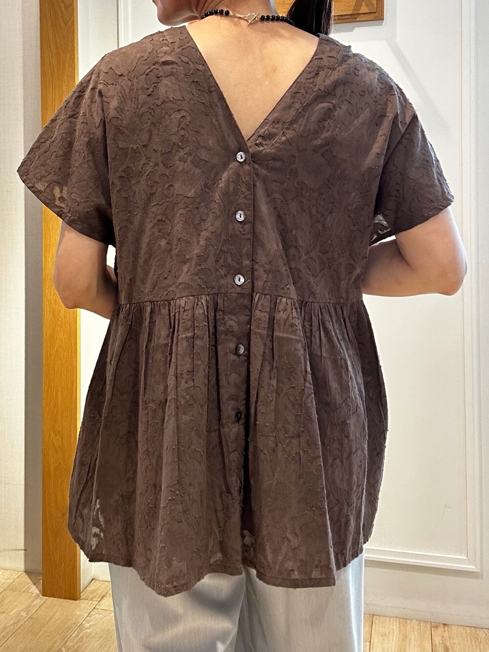 ブラウン系のシャツ/ブラウス、グレー系のその他パンツ、ゴールド系のトートバッグを着用したレディースの夏コーディネートの7枚目の写真