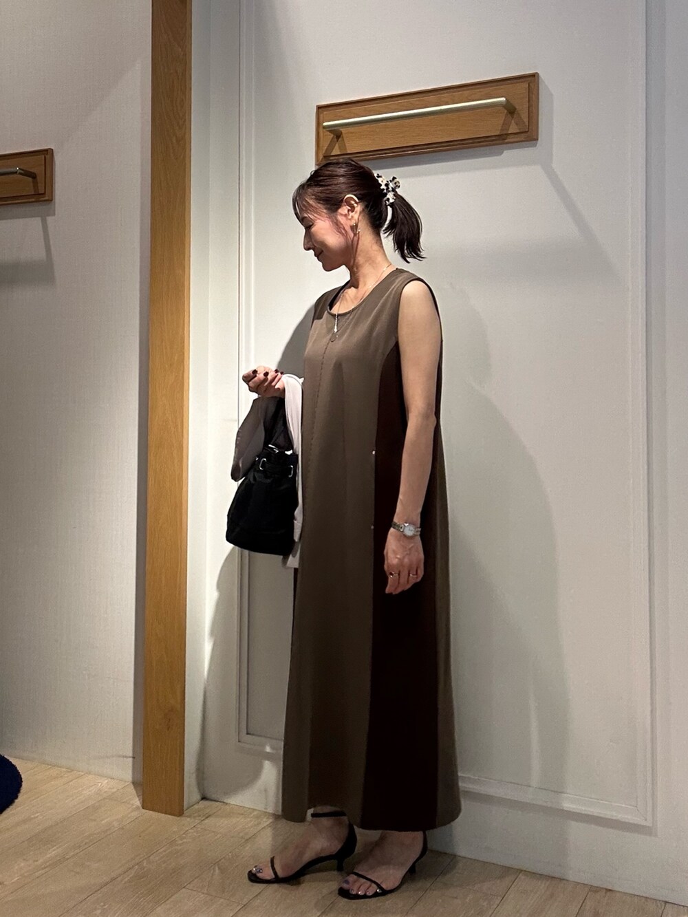 ブラウン系のワンピース、ブラック系のサンダル、ベージュ系のテーラードジャケットを着用したレディースの夏コーディネートの5枚目の写真