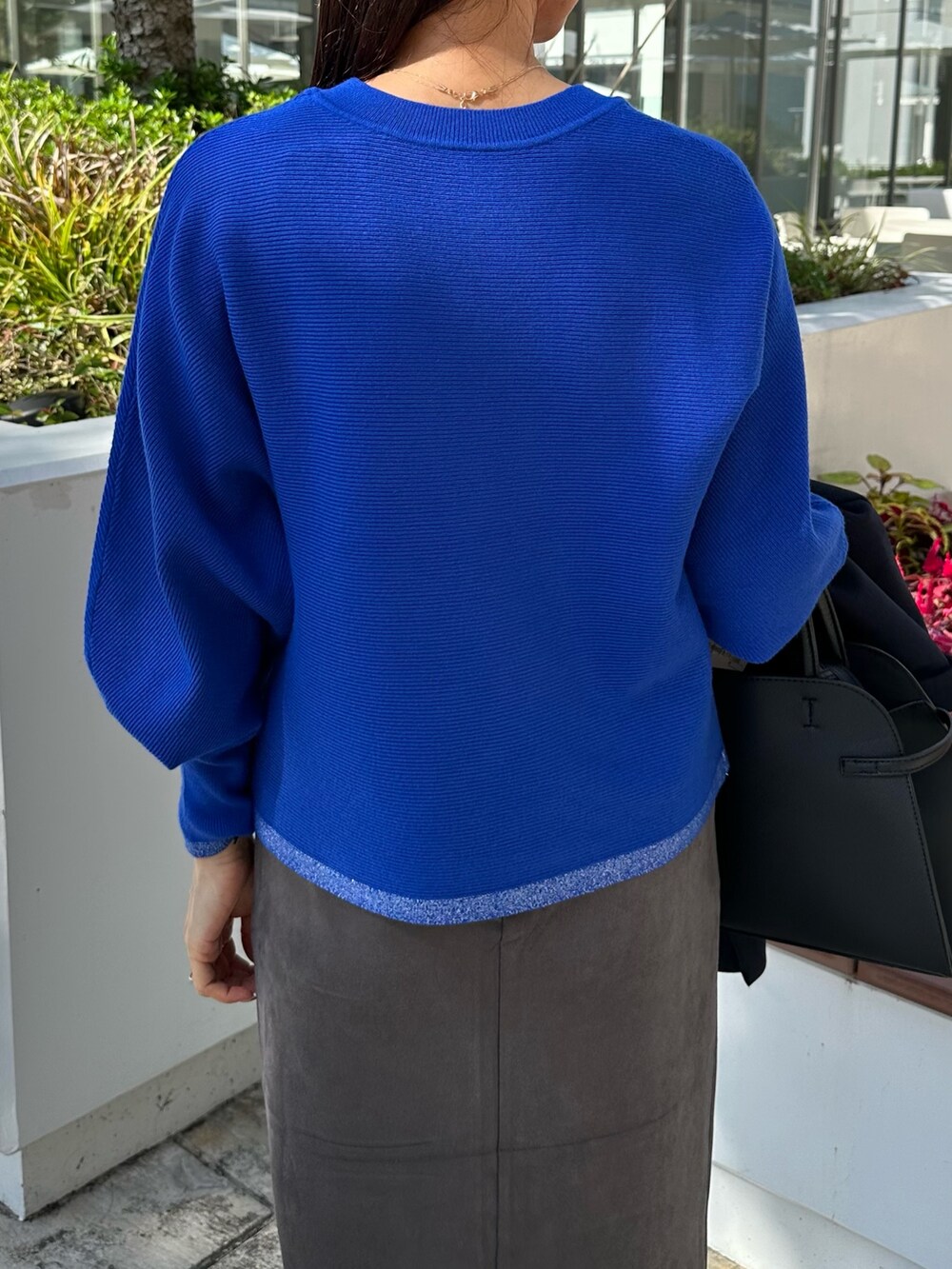 ブルー系のテーラードジャケット、ブルー系のニット/セーター、グレー系のスカートを着用したレディースの秋コーディネートの10枚目の写真