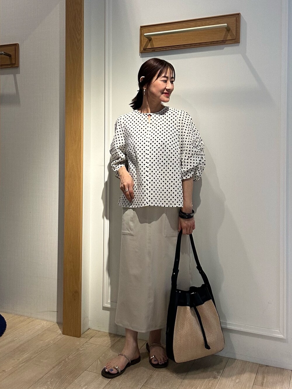 ホワイト系のシャツ/ブラウス、ベージュ系のスカートを着用したレディースの夏コーディネートの5枚目の写真