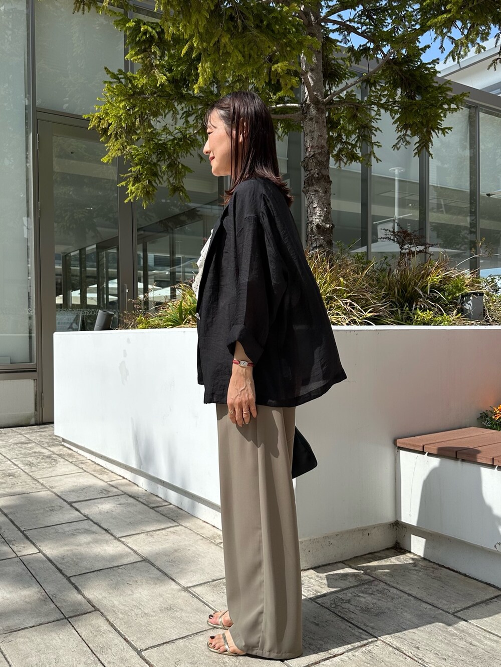 グリーン系のその他パンツ、ブラック系のショルダーバッグ、ホワイト系のシャツ/ブラウスを着用したレディースの春コーディネートの2枚目の写真