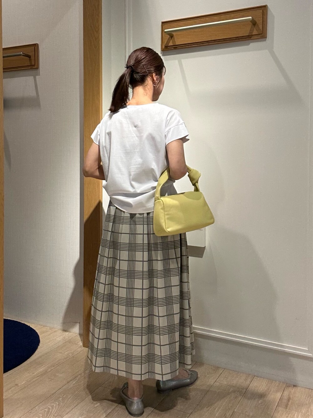 ホワイト系のTシャツ/カットソー、ホワイト系のスカート、イエロー系のショルダーバッグを着用したレディースの春コーディネートの4枚目の写真