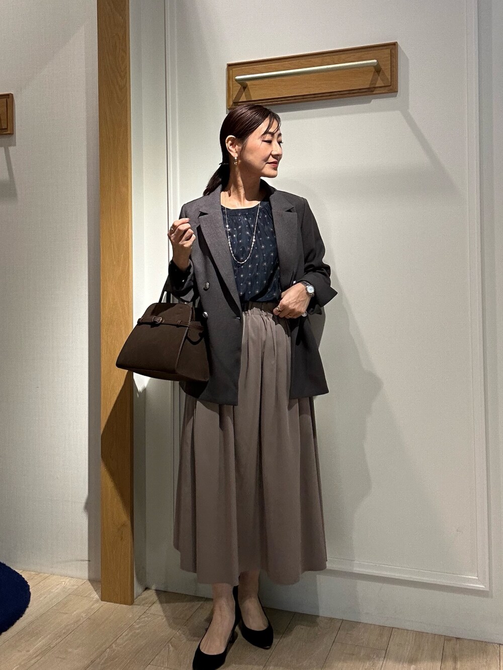 ブラウン系のスカート、ブルー系のシャツ/ブラウス、ブラウン系のトートバッグを着用したレディースの秋コーディネートの8枚目の写真