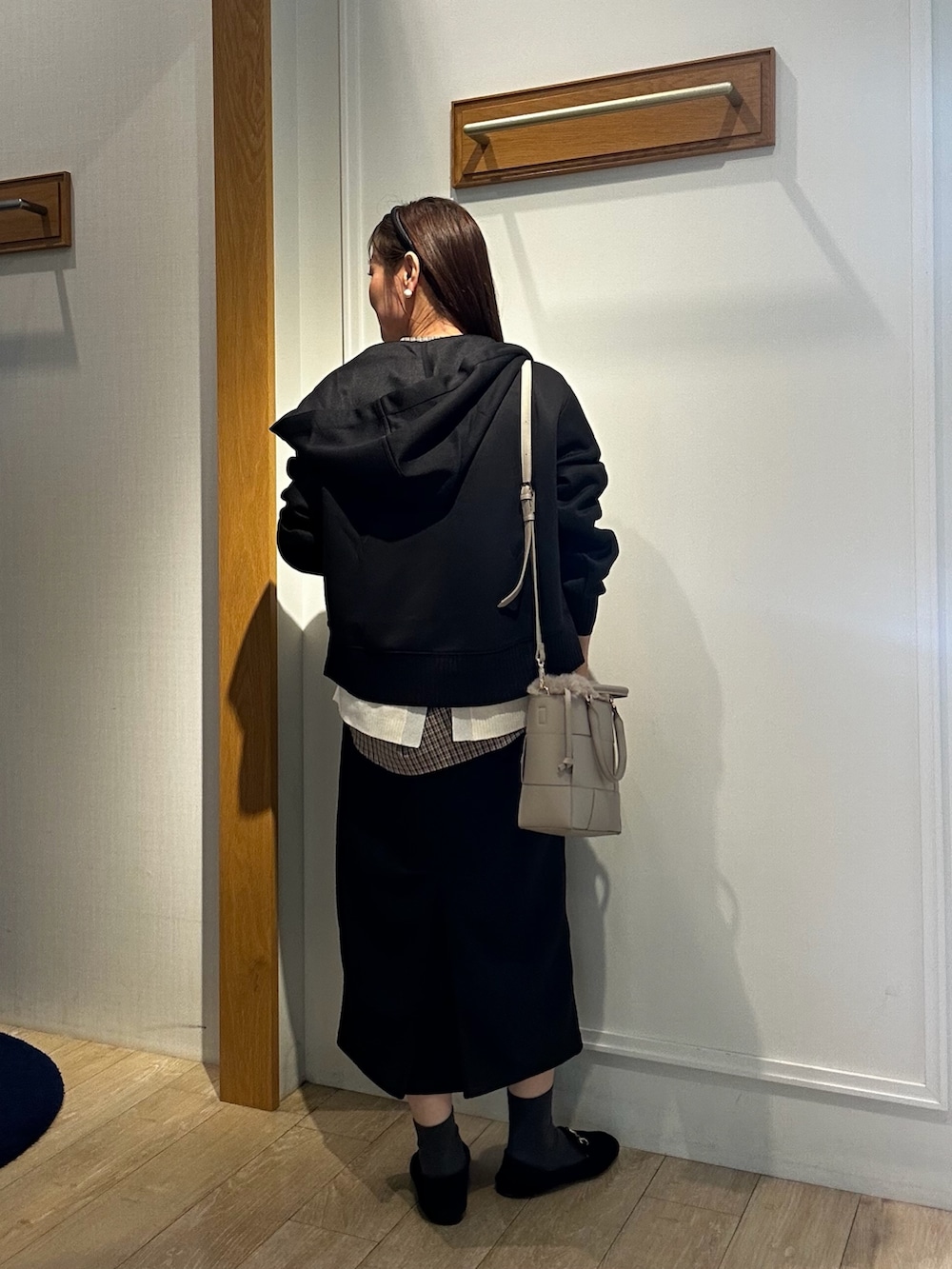 ホワイト系のニット/セーター、ブラック系のスカート、ブラウン系のシャツ/ブラウスを着用したレディースの秋コーディネートの8枚目の写真
