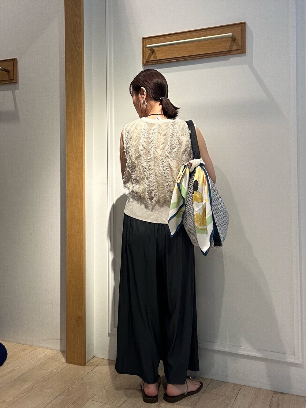 ベージュ系のニット/セーター、グレー系のその他パンツ、グレー系のショルダーバッグを着用したレディースの夏コーディネートの3枚目の写真