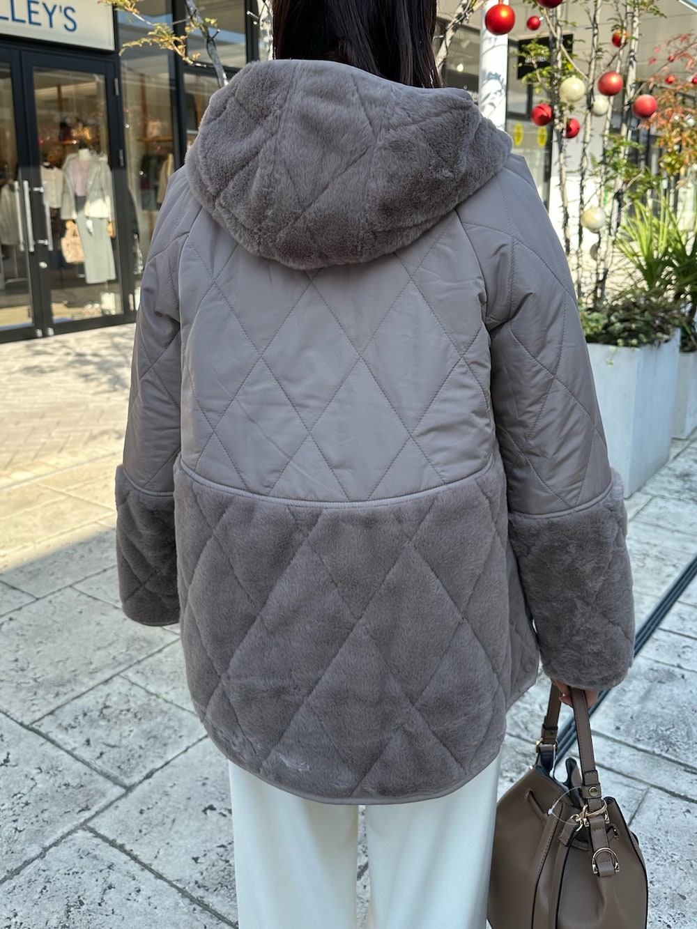 ブラウン系のブルゾン、オレンジ系のニット/セーターを着用したレディースの冬コーディネートの6枚目の写真