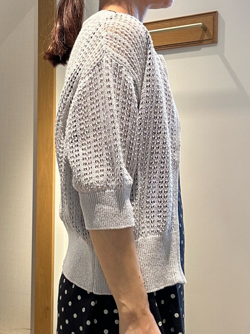 グレー系のニット/セーター、ブラック系のワンピース、ブラック系のサンダルを着用したレディースの春コーディネートの6枚目の写真