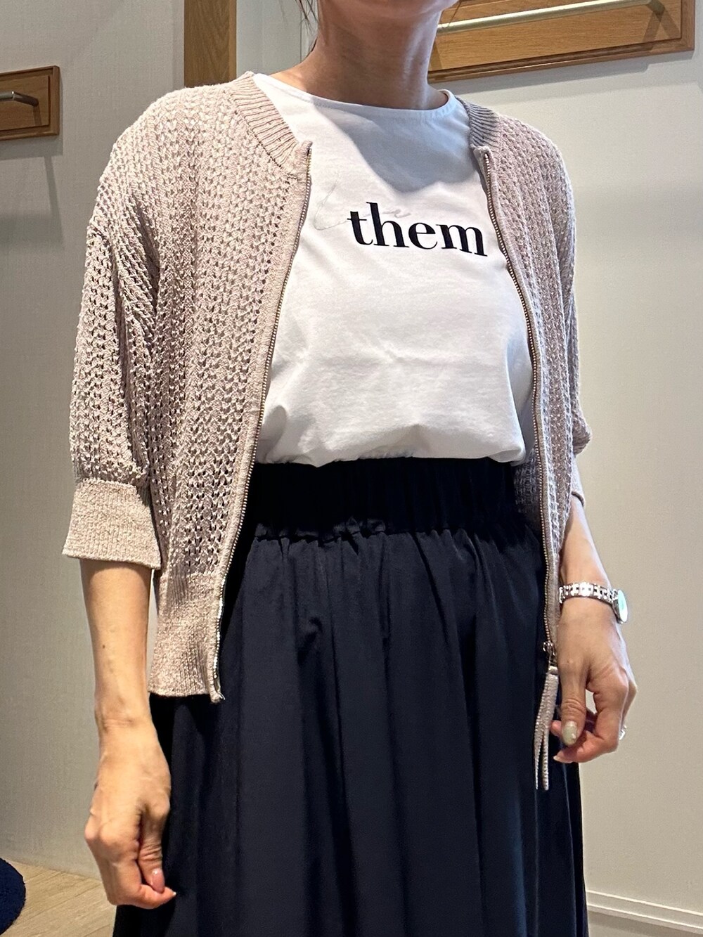 ベージュ系のニット/セーター、ホワイト系のTシャツ/カットソー、ブルー系のスカートを着用したレディースの春コーディネートの4枚目の写真