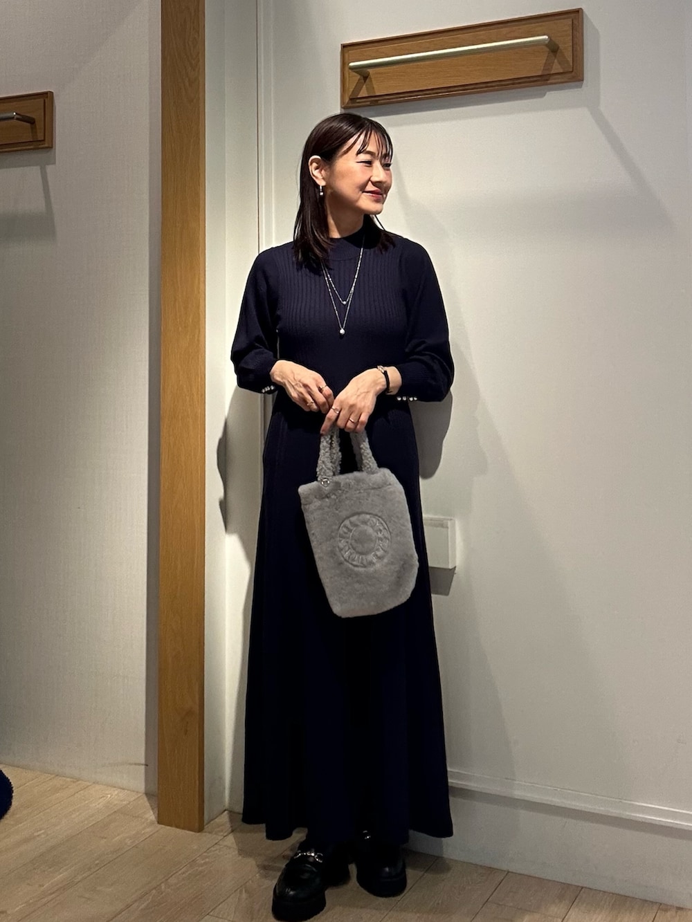 ブルー系のワンピース、グレー系のトートバッグ、ベージュ系のブルゾンを着用したレディースの秋コーディネートの8枚目の写真